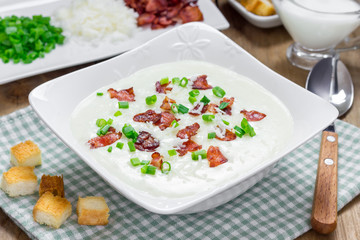 Creamy potato soup garnished with bacon and green onion