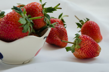 Fresh Strawberries In Bowl On White Fabric Background.