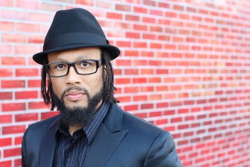 Portrait of handsome bearded African man in black hat and glasses with copy space 
