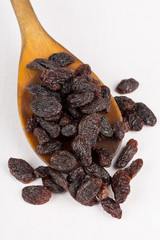 Raisins in wooden spoon on table