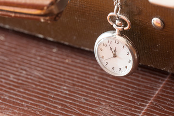 vintage pocket watch closeup on a leather suitcase