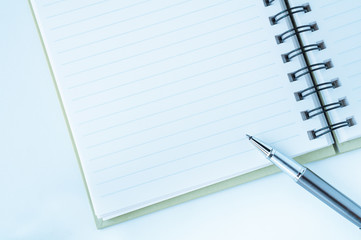 Open notebook with metallic ball pen