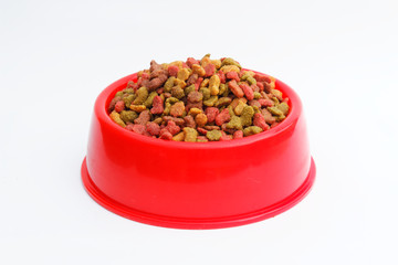 Red pet feeder / bowl filled with dry kibble on isolated background