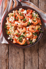 Shrimp saganaki with tomato and feta cheese on a plate. vertical top view 
