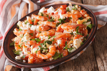 Mediterranean cuisine: shrimp Saganaki close-up on a plate. Horizontal
