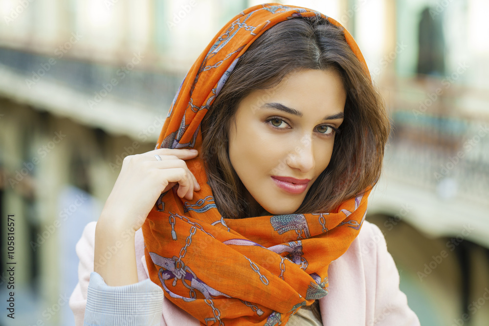 Wall mural close up portrait of a muslim young woman wearing a head scarf