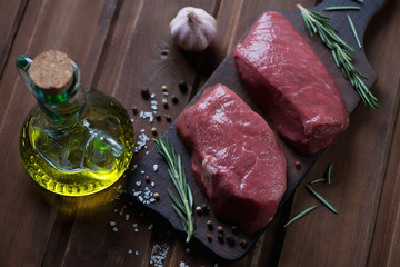 Raw marbled beef asado steaks, seasonings and olive oil