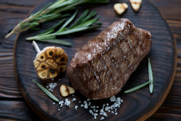 Cooked marbled asado beef steak on a rustic wooden serving board