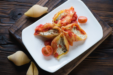Baked conchiglione with cottage cheese stuffing and tomato sauce