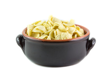 Orecchiette crude in un tegame di terracotta