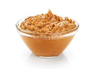 Bowl with peanut butter isolated on white background.
