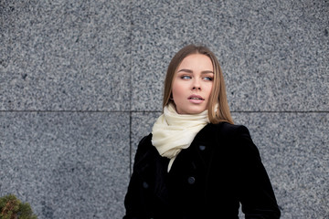 Beautiful blonde young woman in nice black coat. . Fashion Photo