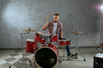 Fototapeta premium Musician playing the drums on brick wall background
