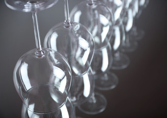 Wine glasses in a row upside down on light grey background