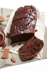 Chocolate sliced cake with icing on on tablecloth