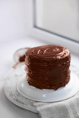 Chocolate cake on a plate on unfocused background