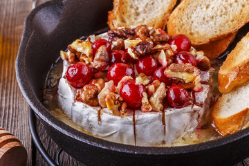 Homemade baked brie with honey, cranberry and walnut.