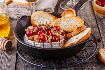 Homemade baked brie with honey, cranberry and walnut.