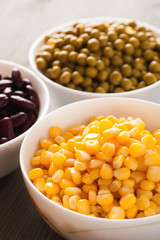 Sweet corn and green peas in white bowls