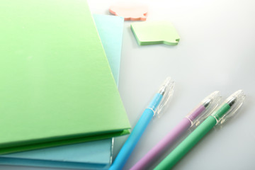 A pile of notebooks and stationary, isolated on white background