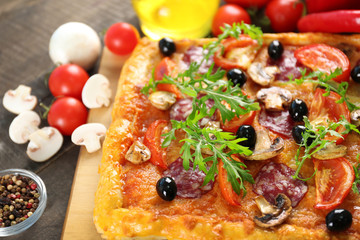 Rectangle delicious pizza and vegetables on the table, close-up