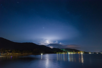 Night lightning strike over mountains resort with star at the Khanom beach of Thailand, Nakhon Si Thammarat province.