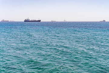 Mediterranean Sea with distant view on several ships and oil platform on horizon. Limassol, Cyprus.
