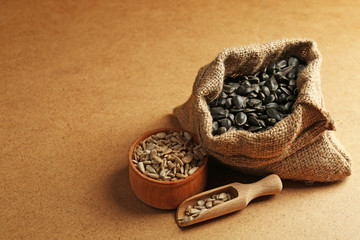 Sunflower seeds in bag on wooden table background, closeup
