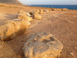 Mediterranean Sea and coastline with large boulders at sunset. Cape Greko, Cyprus.
