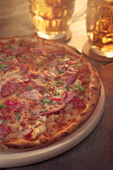 Delicious pizza  and glasses of beer are on wooden table, close up