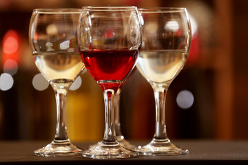 Glasses of red and white wine against blurred background