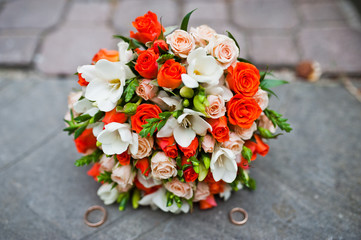 Obraz na płótnie Canvas Wedding bouquet of white and orange roses and with two wedding r