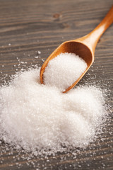 Sugar with spoon on a wooden table