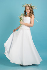 Bride with wreath of flowers isolated on blue