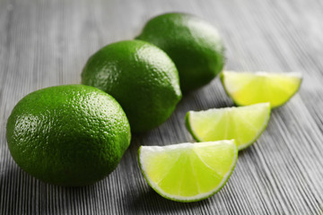 Limes and slices on wooden table, closeup