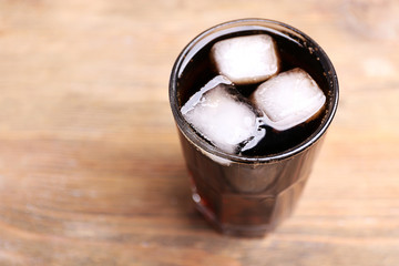 Glass of water with ice blocks  on wooden background, close up