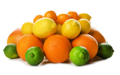 A heap of mixed citrus fruit including   lemons, limes, grapefruits, oranges and tangerines isolated on a white background, close up