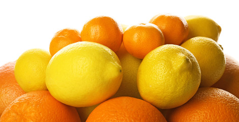 A heap of mixed citrus fruit including   lemons, oranges and tangerines isolated on a white background, close up