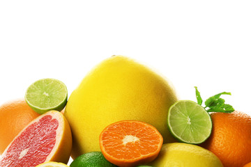 Mixed citrus fruit including lemons, limes, grapefruit, pomelo and tangerines with mint sprigs isolated on a white background, close up