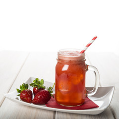 Batido, smoothie o zumo de fresa natural fresco sobre mesa de madera y fondo blanco en mason jar.