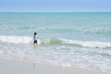 A cute little girl in playing with a toy on the beach on a warm sunny summer day. Holidays at sea. Funny kids