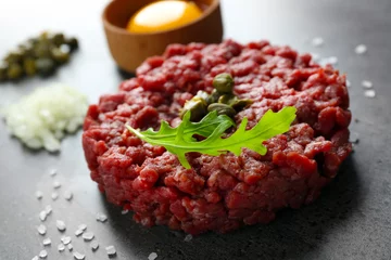 Stoff pro Meter Beef tartare served with an egg yolk on a grey surface, close up © Africa Studio