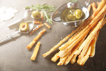 Bread sticks grissini with sesame seeds on a dark surface, close up