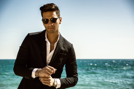 Handsome man in classical suit on beach