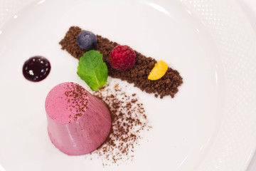 Frozen berry parfait with cocoa powder and fruits, top view.