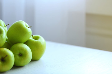 Ripe green apples on a kitchen table