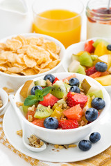 breakfast with fruit salad and corn flakes on white table