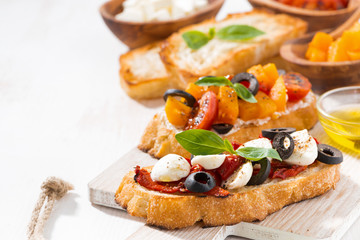 bruschettas with tomatoes and mozzarella on wooden board