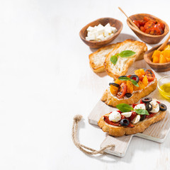 bruschettas with tomatoes and mozzarella on wooden board