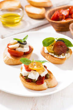 bruschettas with tomatoes and mozzarella on white plate